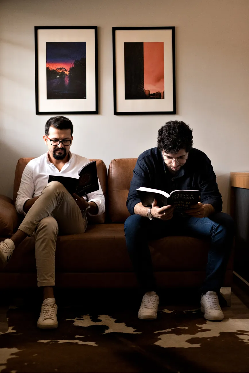 dois homens sentados no sofá lendo um cada um livro cada um